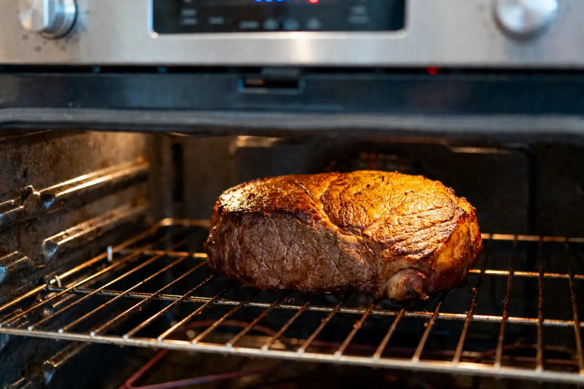 Rôti de bœuf cuit au four sur grille métallique, bien doré et appétissant.