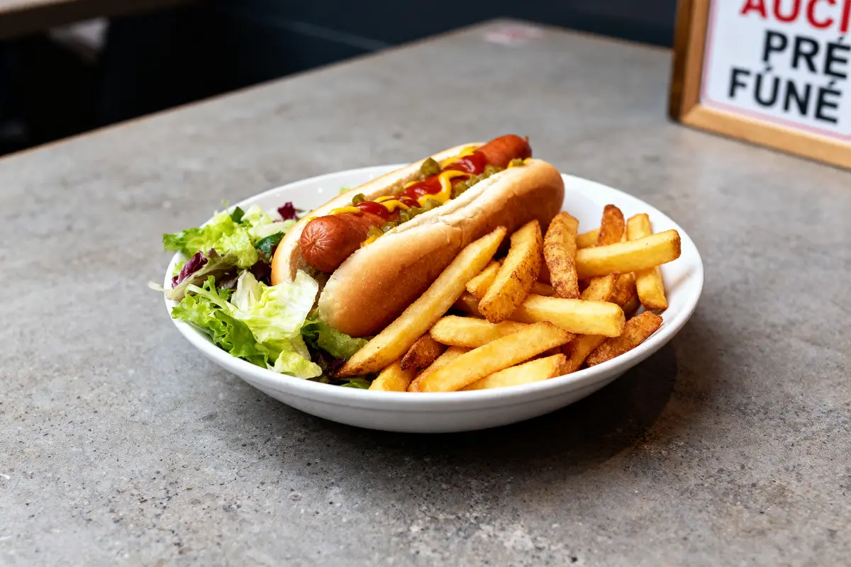 Assiette avec hot dog, frites et salade comme accompagnement pour hot dog savoureux