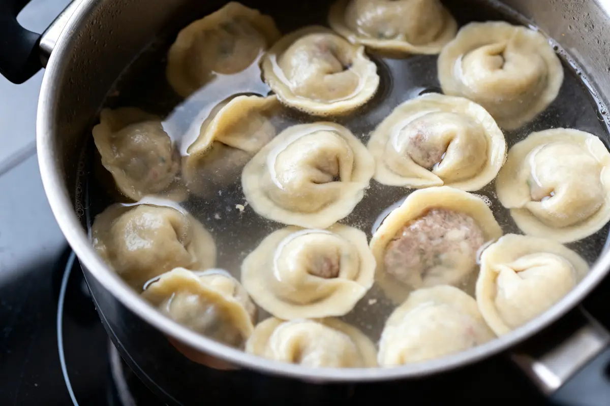 Cuisson des dumplings pelmeni dans une casserole d'eau bouillante sur la cuisinière
